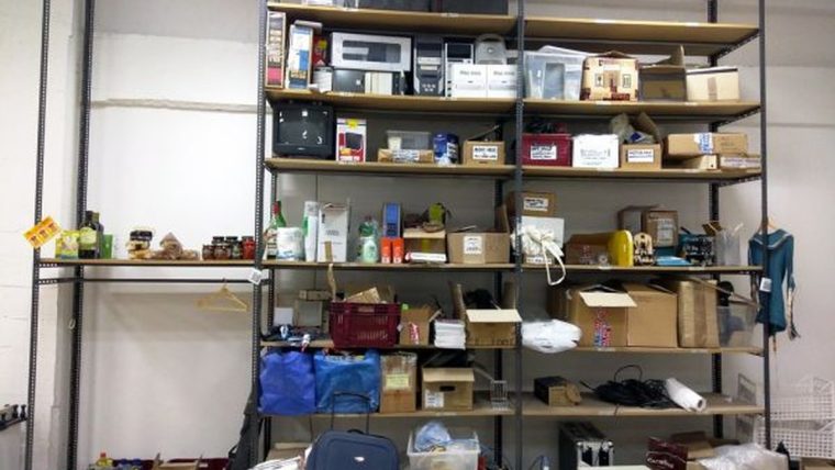 Compact shelf organizers arranged in a small apartment with a measuring tape