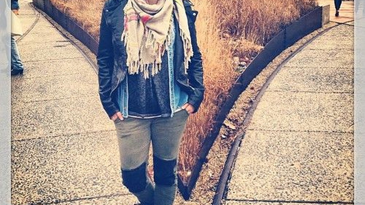 A transitional layered outfit with a fitted top, cardigan, and trousers